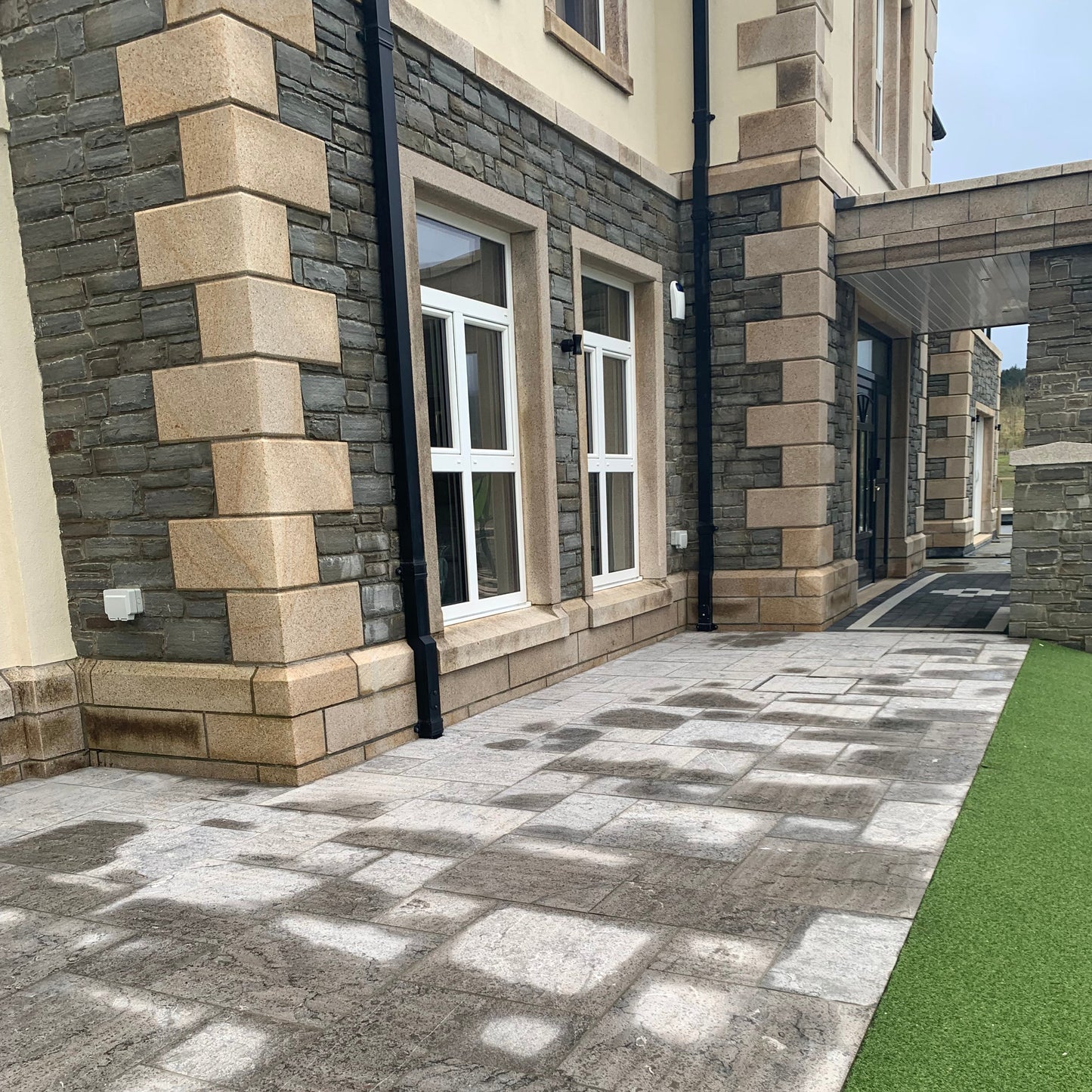Building exterior with stone facade and gold granite window surrounds. 