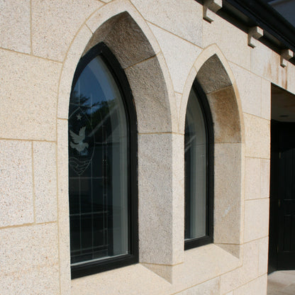 Arched Gold Granite window Surrounds in a Church Building Façade.