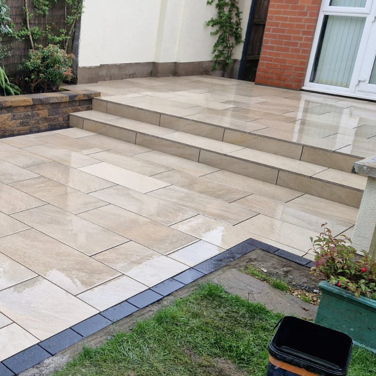 Paved patio area with garden steps and plants in a residential setting. Paving is Gold Quartz Diva Range Porcelain Paving. 