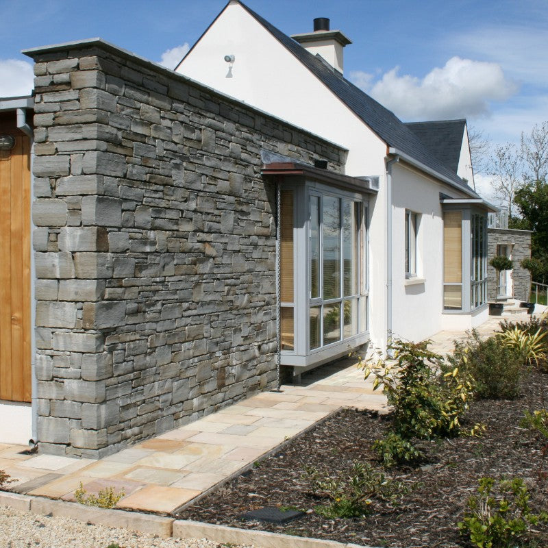 Modern house with stone feature wall in grey sandstone machined walling.