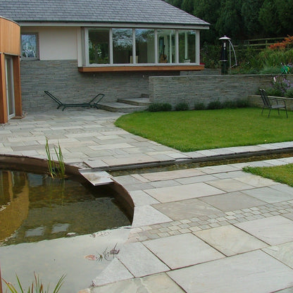 Modern patio area with water feature and garden. Paving is Grey Sandstone. 