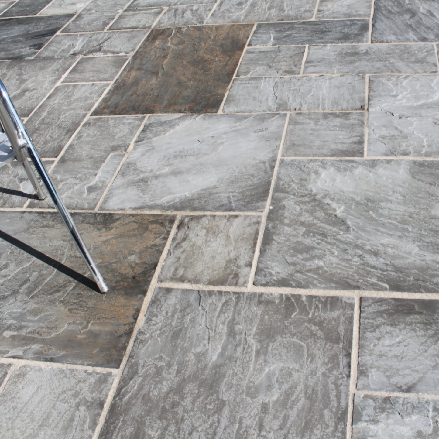 Close up of Grey Sandstone Paving in patio pack sizes showcasing the natural riven finish and grey colour variations. 