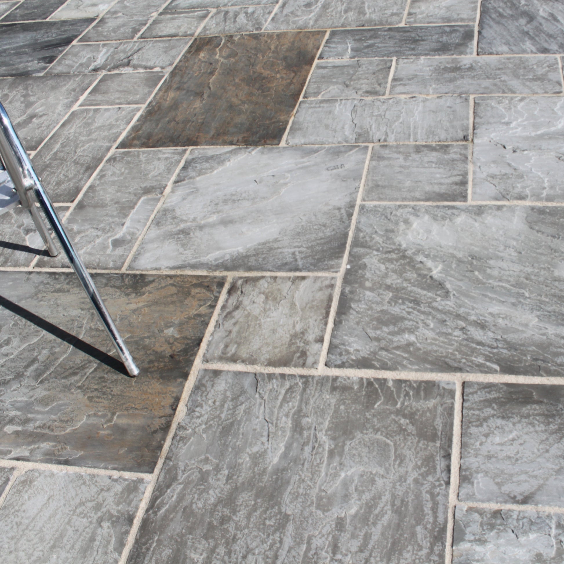 Close up of Grey Sandstone Paving in patio pack sizes showcasing the natural riven finish and grey colour variations. 