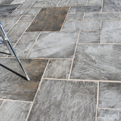 Close up of Grey Sandstone Paving in patio pack sizes showcasing the natural riven finish and grey colour variations. 