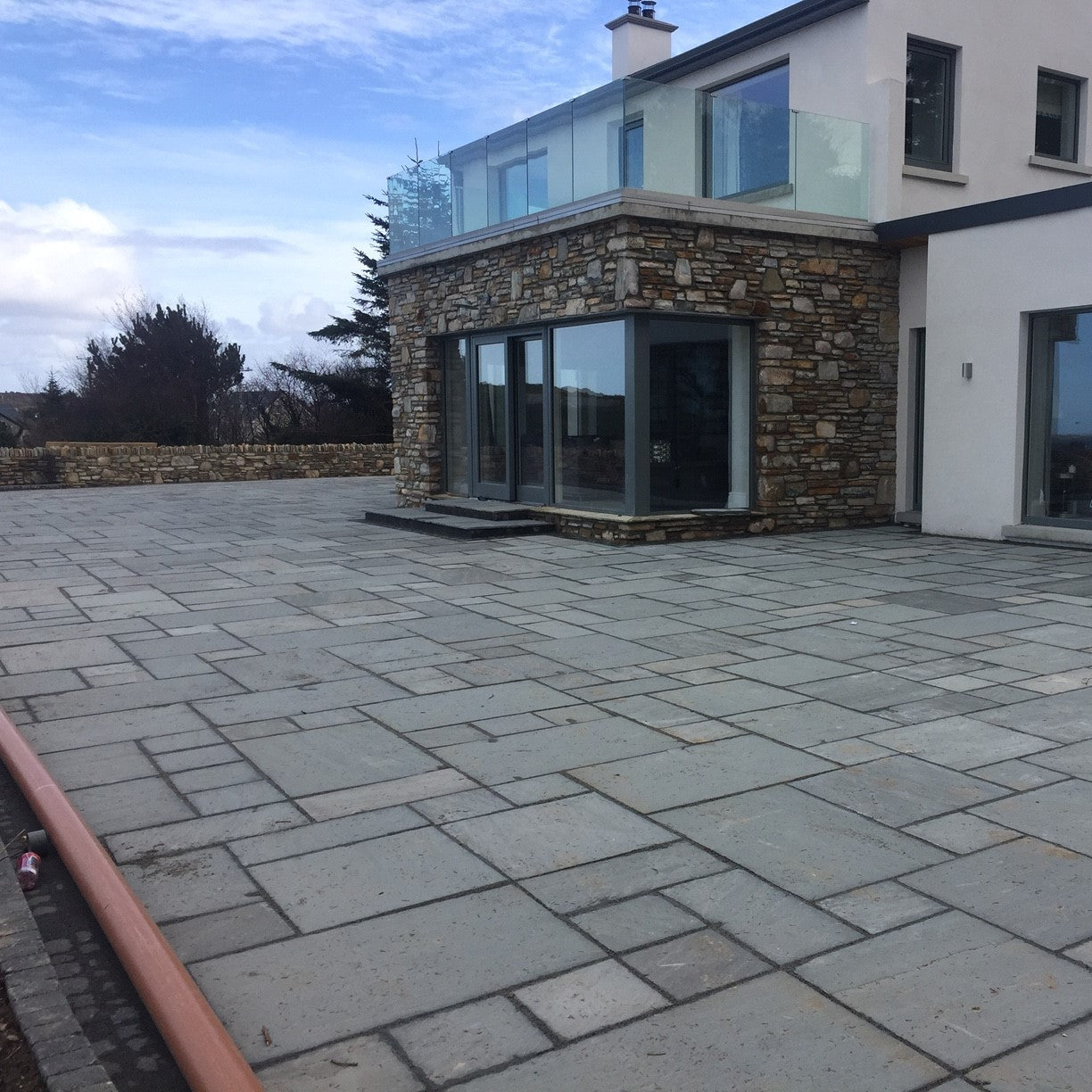 Large patio area featuring Grey Sandstone Paving. 