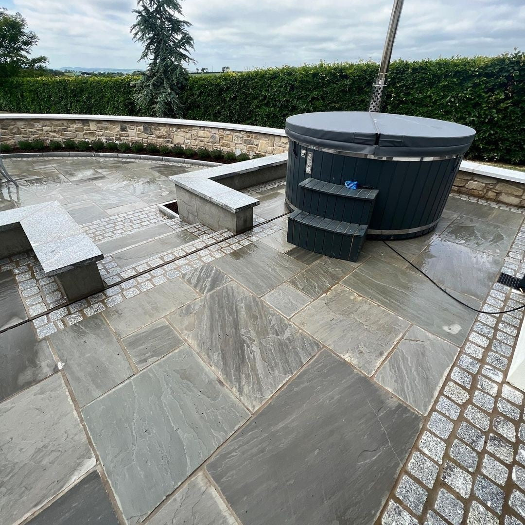 Patio with hot tub. Paving is Grey Sandstone Patio Pack (Mixed Sizes) Bordered with Silver Granite Cobbles. 