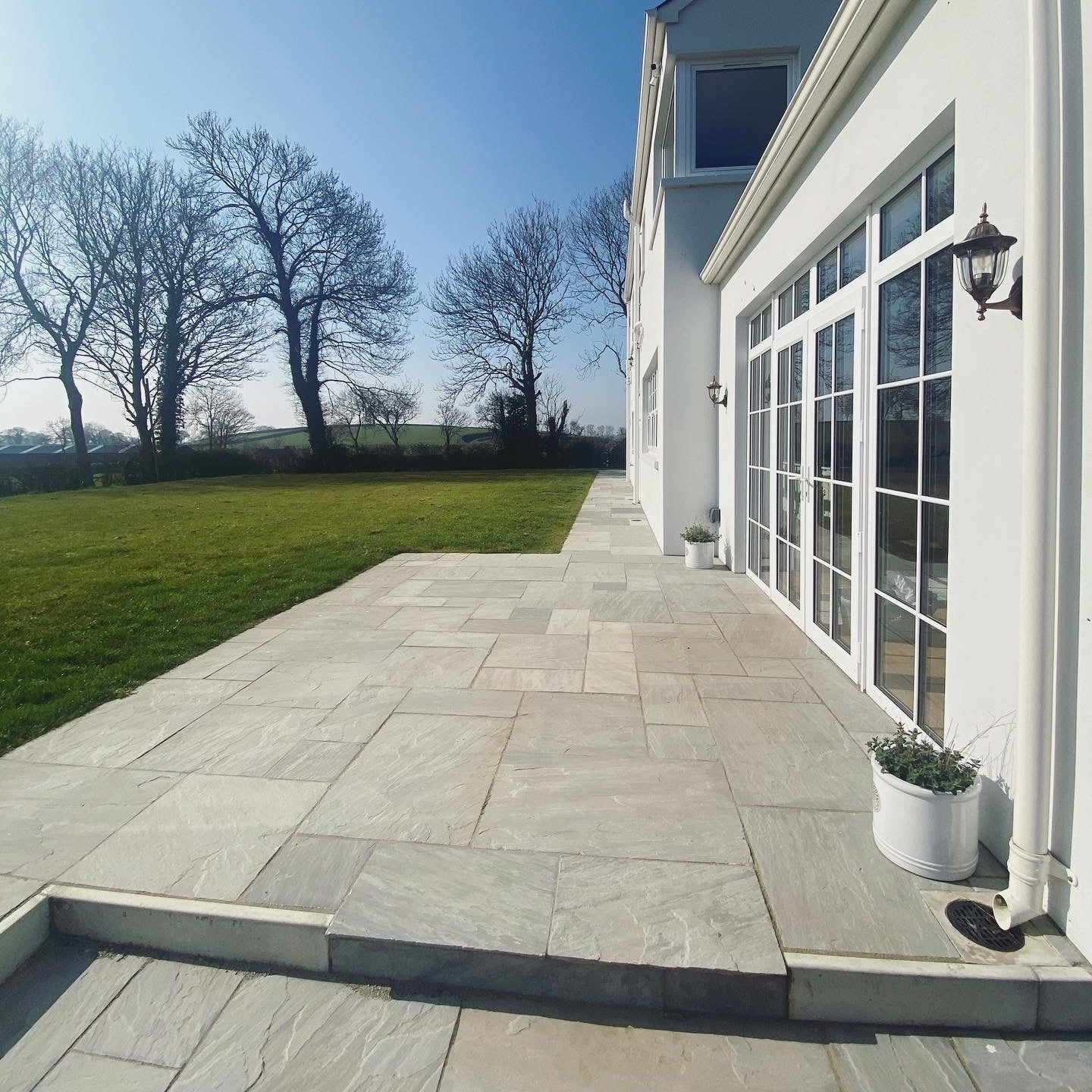 Modern white new build with patio area and pathway completed in Grey Sandstone Paving. 