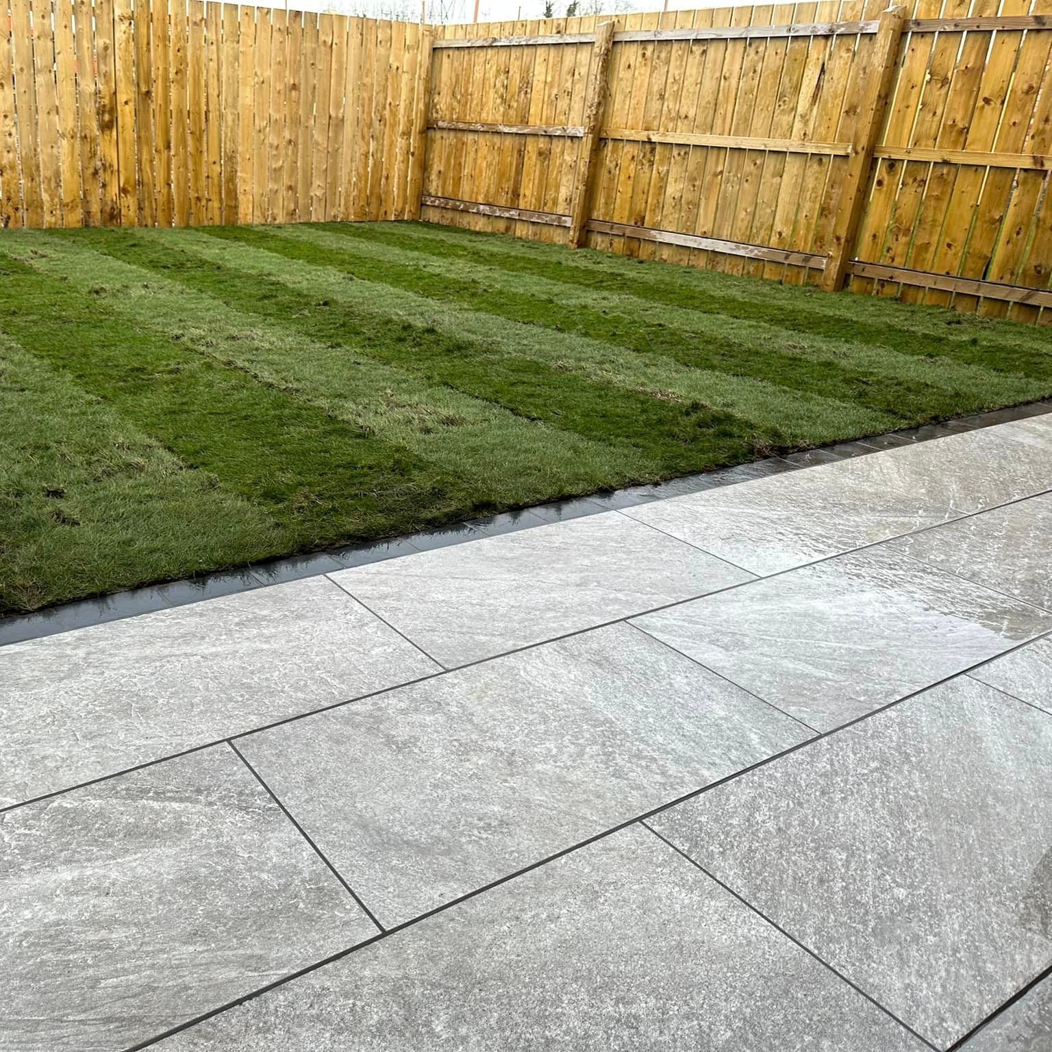 Patio area and garden featuring Grey Twice Qz Range Porcelain Paving Tiles. 
