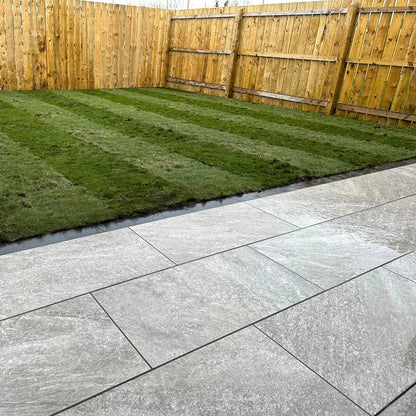 Patio area and garden featuring Grey Twice Qz Range Porcelain Paving Tiles. 