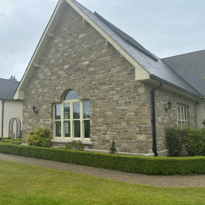 Stone house in Grit Sandstone with a well-maintained garden and driveway