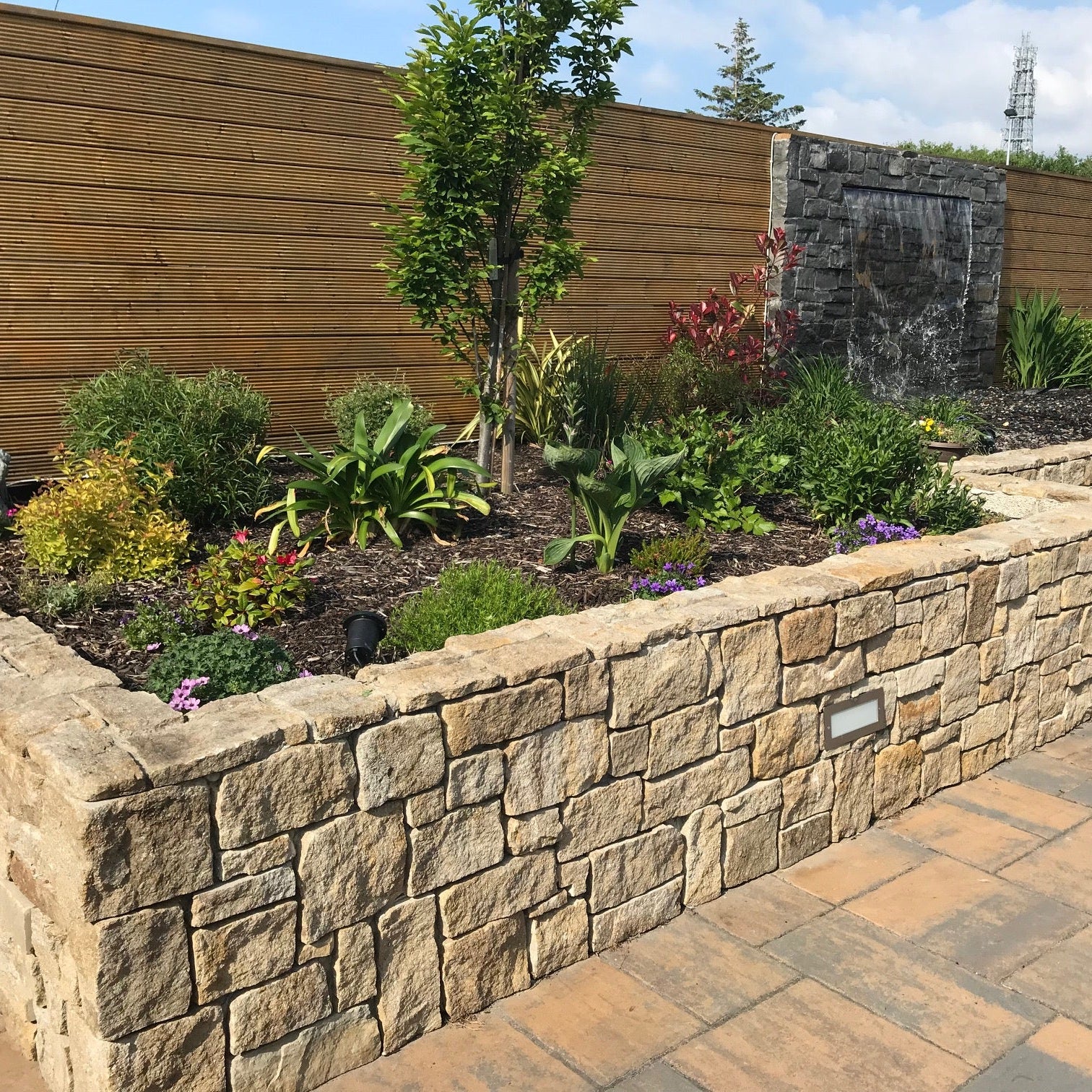 Hotel garden wall featuring Grit Sandstone Stoneer Cladding. 