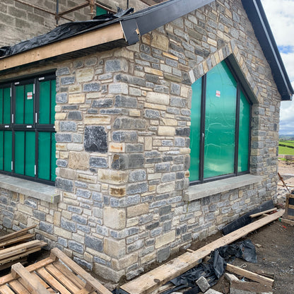 House under construction with stone outshot finished in Highland Blend Tumbled.