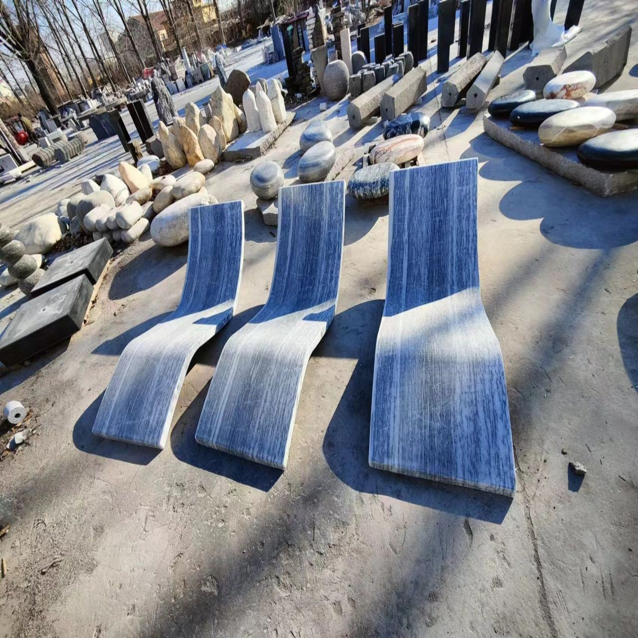 A polished marble bench laid out on a flat surface, likely made for garden or outdoor use.