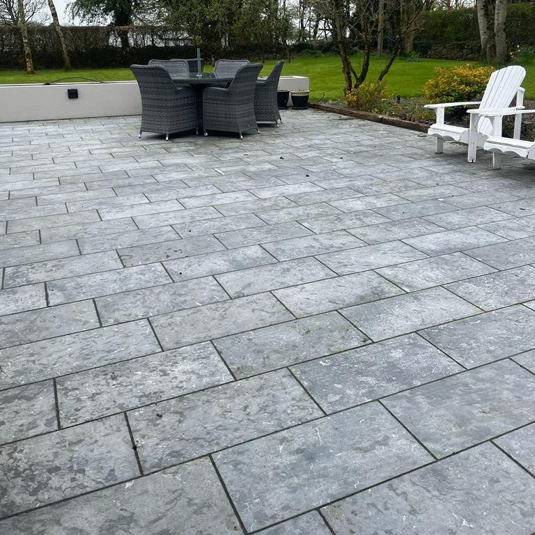 Paved patio area in Irish Blue Limestone Paving with outdoor furniture and trees in the background