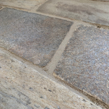Close up of JOINTEX Easy Extra Fine Stone Grey grout between sandstone cobbles. 