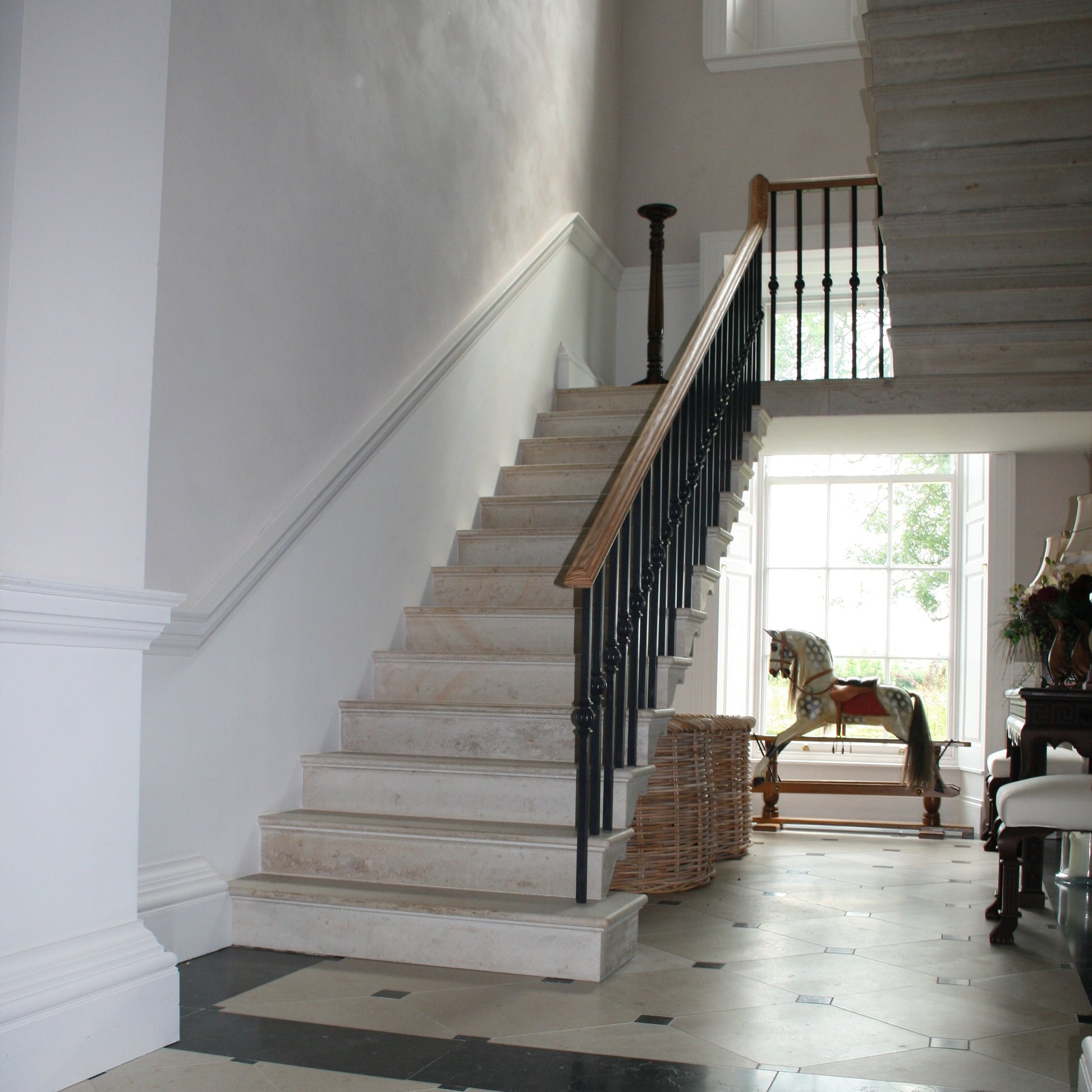 Bespoke Limestone Cantilevered Staircase with black railing. 
