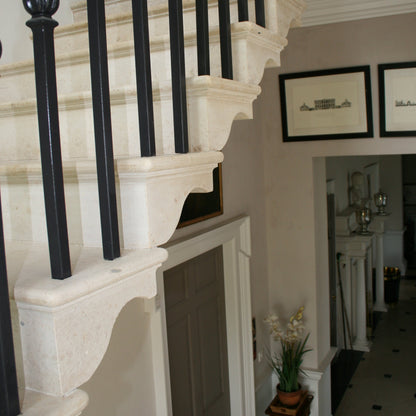 Bespoke Limestone Staircase with black balusters in a home interior.