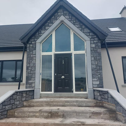 House exterior with stone façade and large Blue Limestone Door Surround 