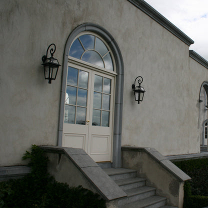 Stately building with arched windows completed with bespoke blue limestone surrounds and steps leading up to a door.