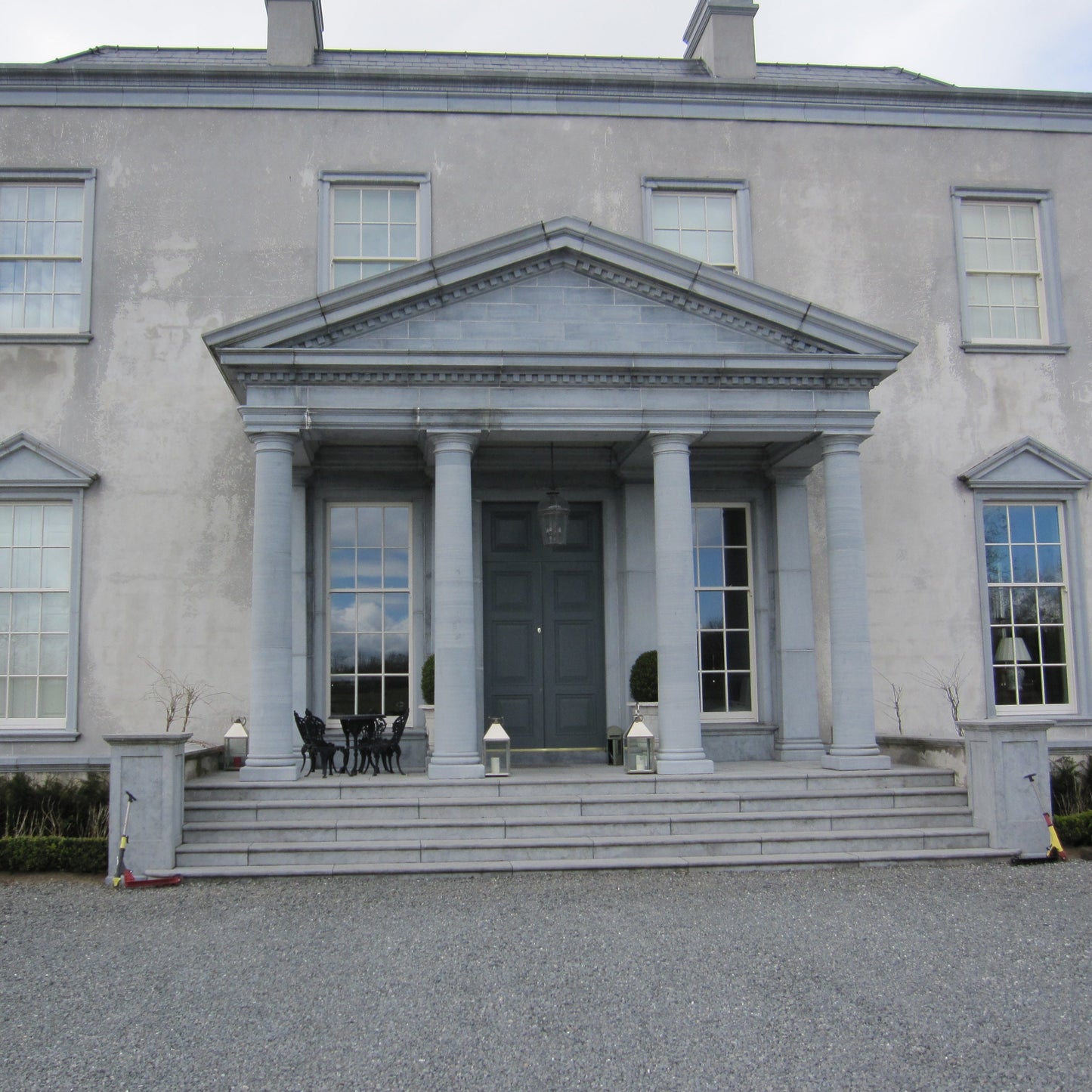 Large grey mansion with bespoke Limestone Portico and steps leading to the entrance