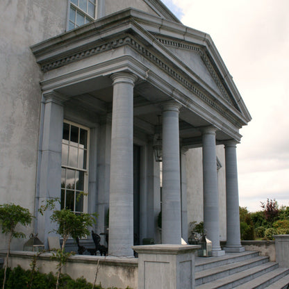 Stately home with classical columns and steps leading up to the entrance. 