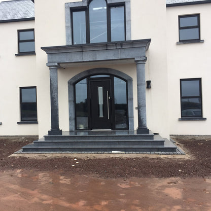 Modern house with a limestone portico and black door and windows