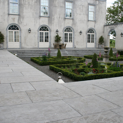 Large stone building with a well-maintained garden in front. Building features bespoke Blue Limestone Window & Door Surrounds. 