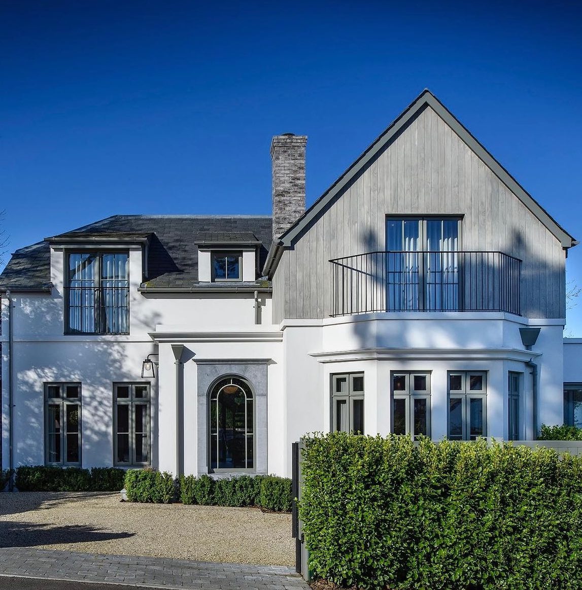 Two storey house with bespoke Limestone Window Surround with well maintained driveway and hedging on a sunny day. 