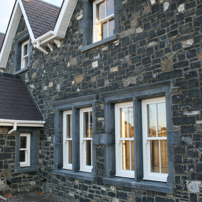 Stone building with bespoke blue limestone window surrounds. 