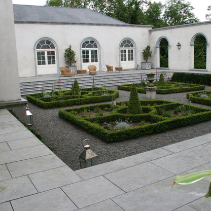 Neatly maintained courtyard garden with bespoke limestone window arches and door surrounds.