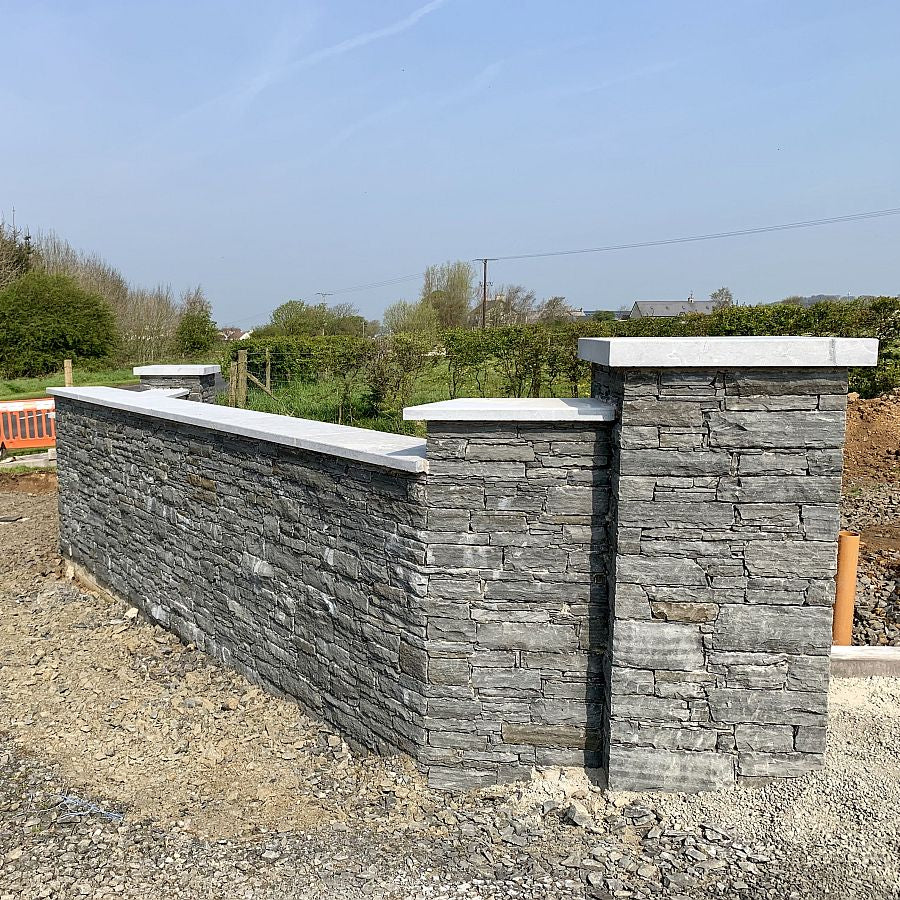 Boundary wall finished in Liscannor Slate machined building stone with silver granite wall and pillar capping.