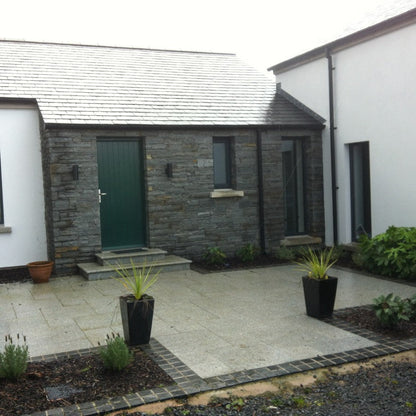 Stone feature wall at front entrance in grey Liscannor Slate machined building stone. 