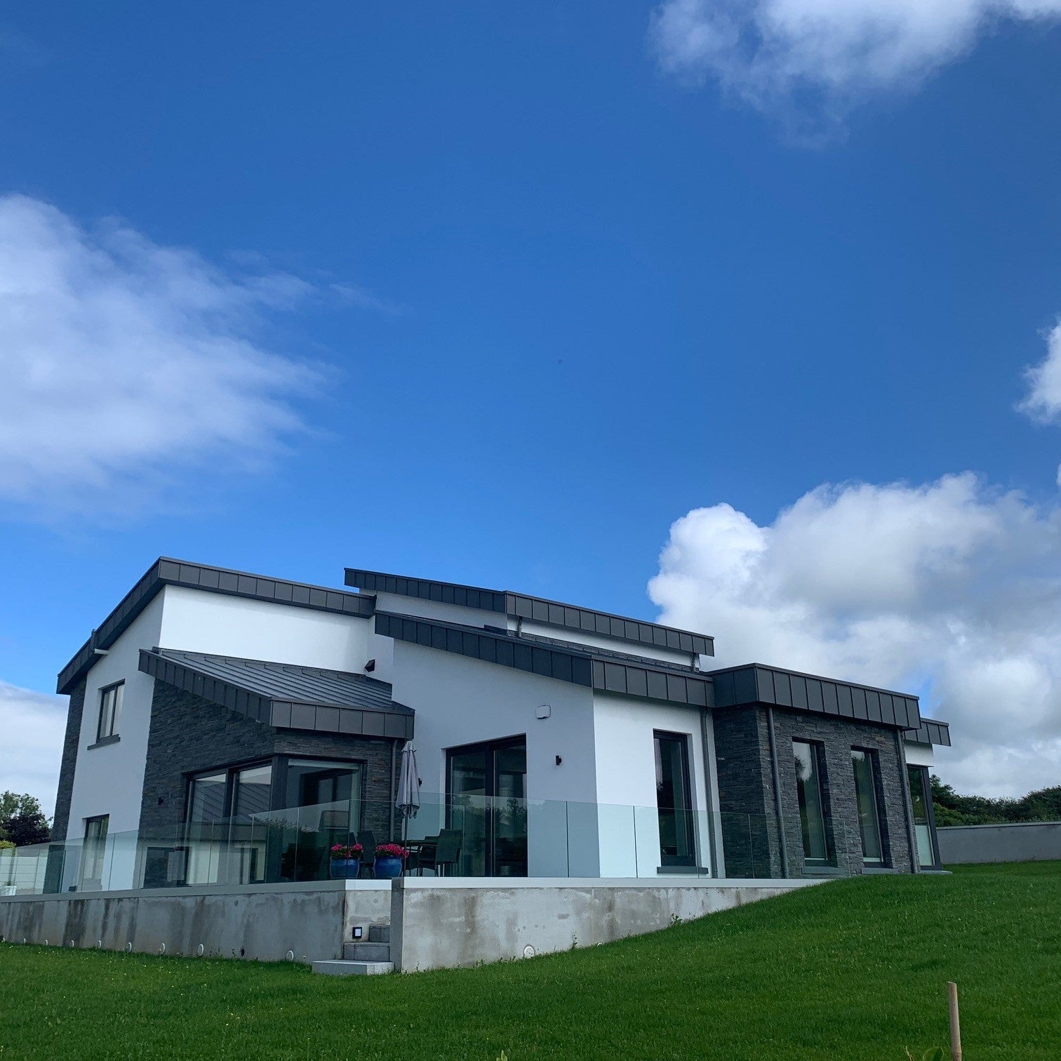Contemporary new build featuring Liscannor Stoneer cladded feature walls on a clear day. 