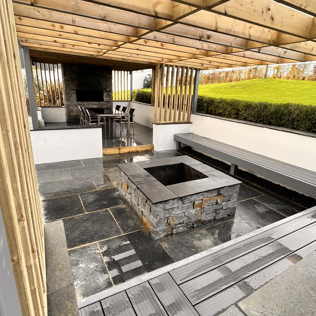 Patio BBQ area featuring a firepit and tv wall cladded in Liscannor Slate Stoneer Cladding. 