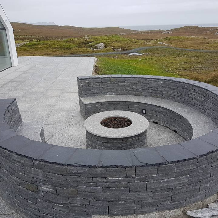 Circular firepit and seating cladded in Liscannor Slate Stoneer Cladding. 