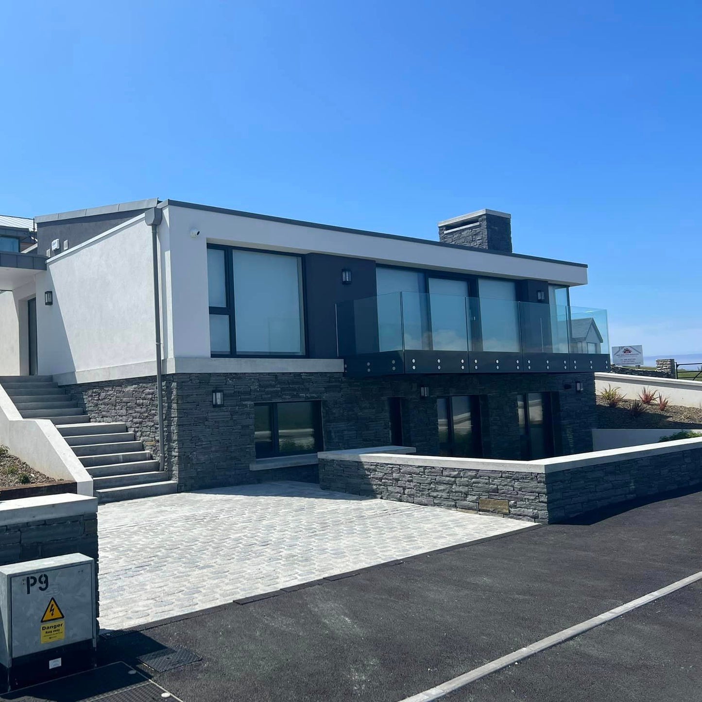 Modern stone clad house with a clear blue sky. Stonework is Liscannor Slate Stoneer Cladding. 