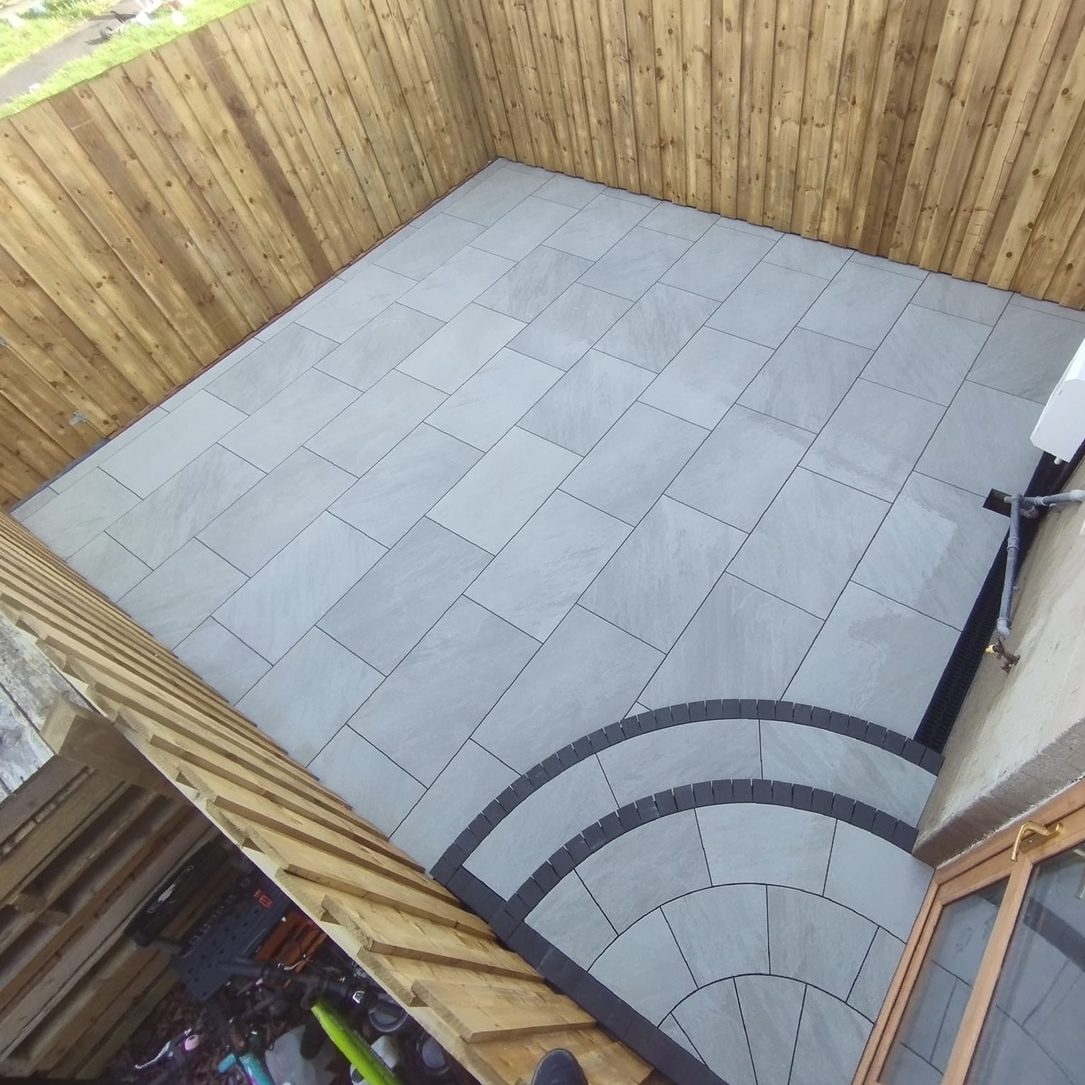 Small patio area with steps featuring Mercury Grey Jewel Range Porcelain Paving. 