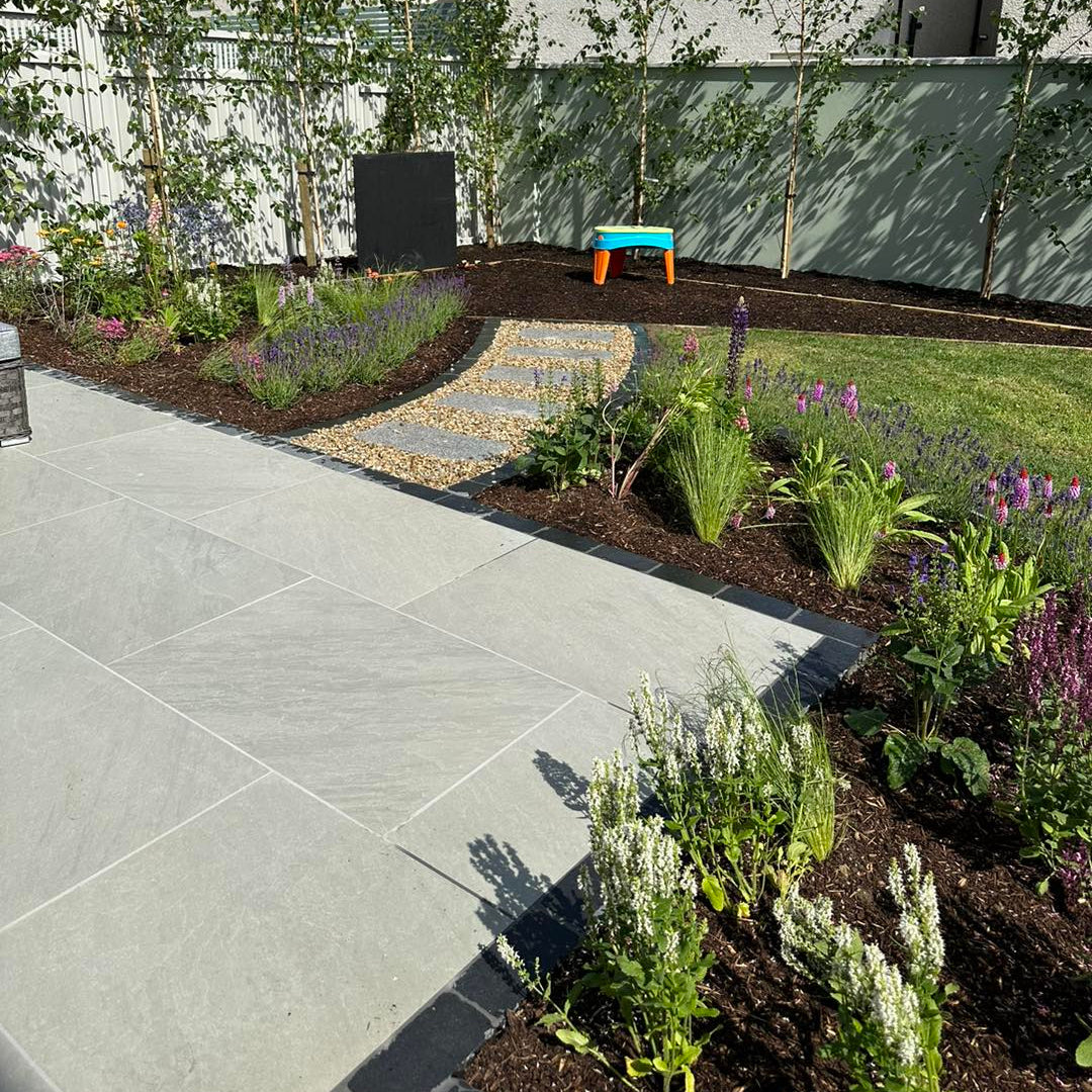 Garden with patio area featuring Mercury Grey Jewel Range Porcelain Paving. 
