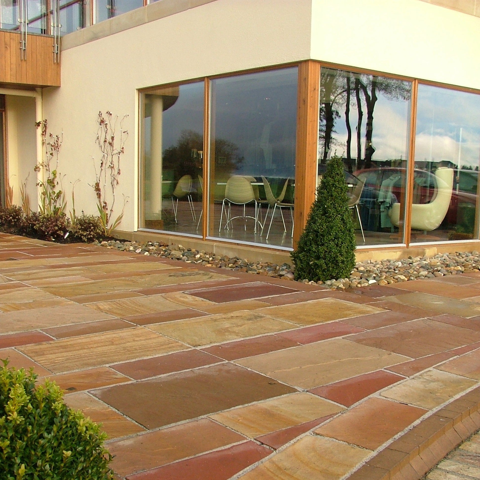 Golf club with large windows looking out onto paved area completed using Modak Sandstone Paving.
