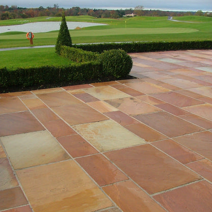 Patio area at golf club completed featuring Modak Sandstone Paving in mixed patio pack sizes. 