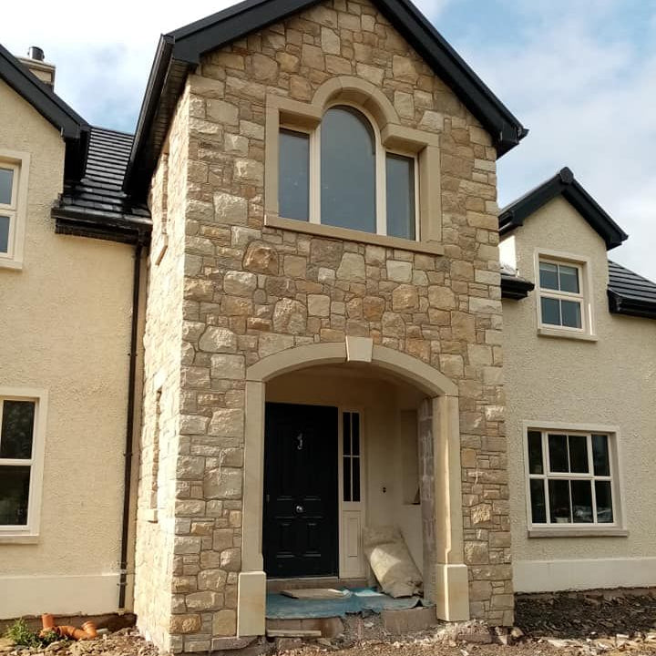 Stone entrance with bespoke sandstone door and window surround. 