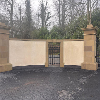 Boundary wall with bespoke sandstone door surround with black metal gate. 