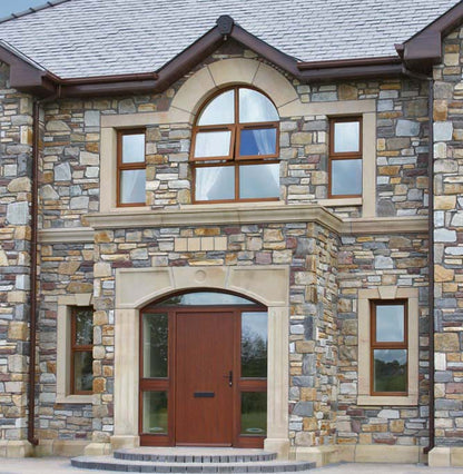 Stone building façade with bespoke sandstone windows and door surround. 