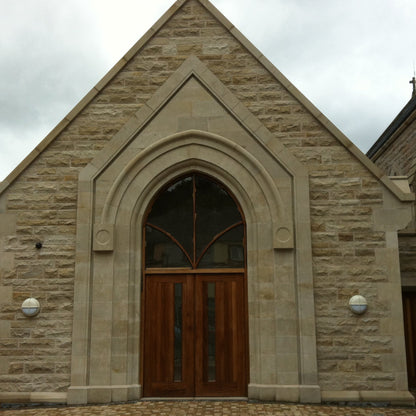 Church building with large architectural sandstone door surround. 