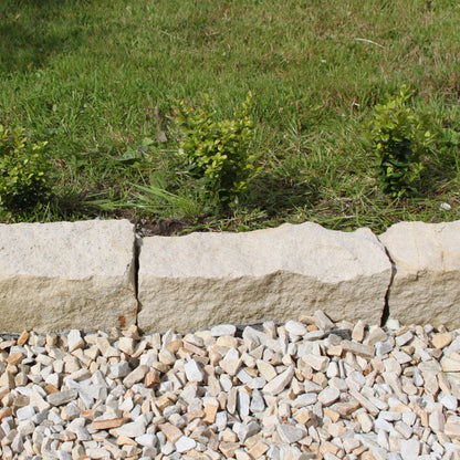 Close up of Mountcharles Sandstone Kerbs installed between a garden and stone chipping pathway. 