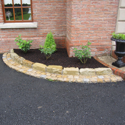 Red brick house with planting surrounded by Mountcharles Sandstone Kerbing. 