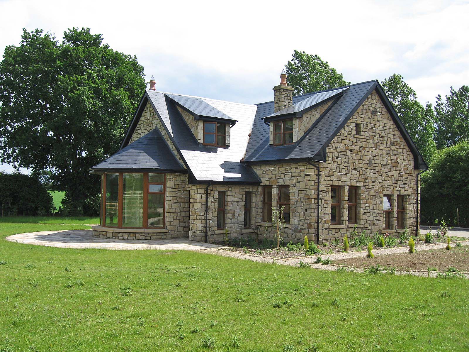 Stone house completed using Mountcharles Sandstone Machined photographed in a rural setting.