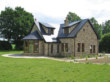 Stone house completed using Mountcharles Sandstone Machined photographed in a rural setting.