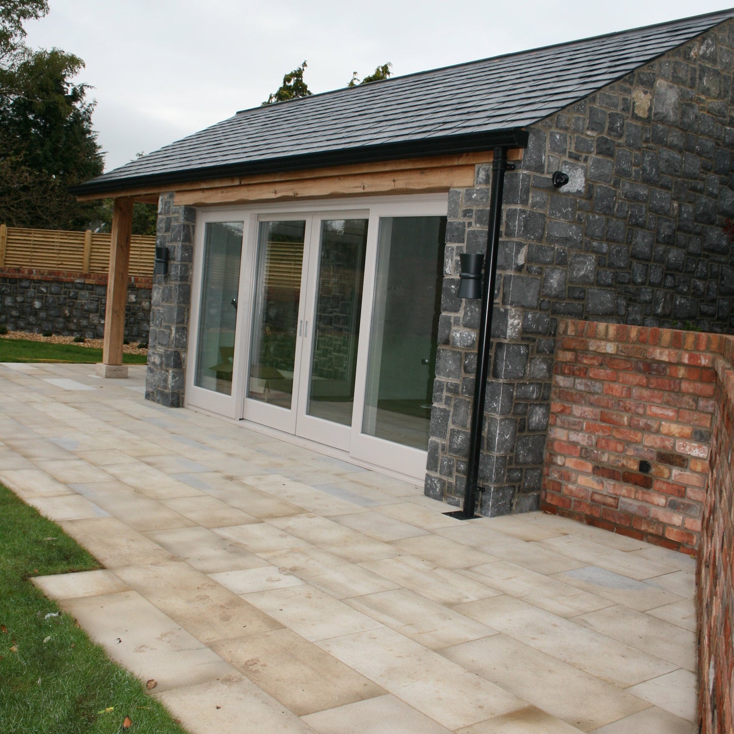 Patio area outside stone garden room completed using Mountcharles Sandstone Paving Slabs. 