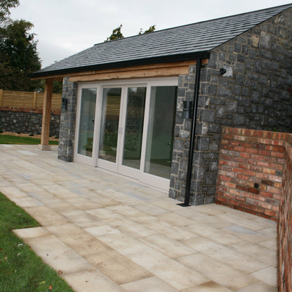Patio area outside stone garden room completed using Mountcharles Sandstone Paving Slabs. 